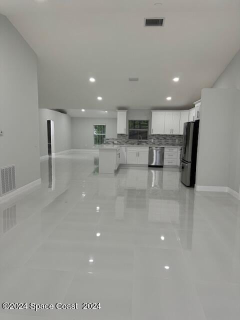 kitchen featuring freestanding refrigerator, open floor plan, visible vents, and dishwasher