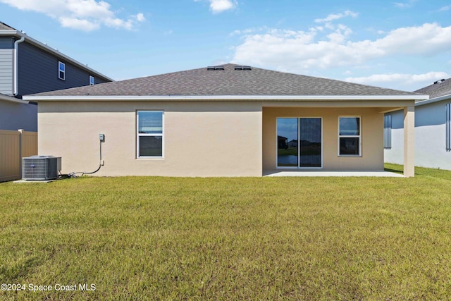 rear view of property featuring a lawn, a patio, and central AC unit