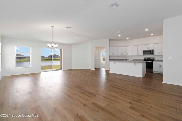 unfurnished living room with sink, light hardwood / wood-style floors, and a notable chandelier