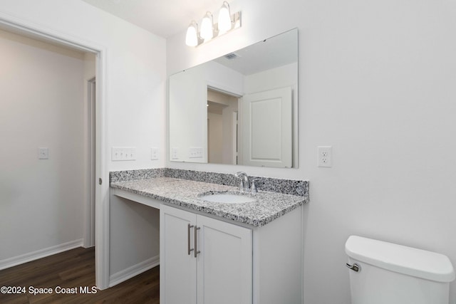 bathroom with hardwood / wood-style floors, vanity, and toilet