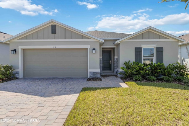 3480 Aramore Rd SE, Palm Bay, FL 32909 - ranch-style home with board and batten siding, an attached garage, a front lawn, and decorative driveway