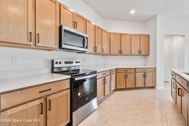 kitchen with appliances with stainless steel finishes, recessed lighting, light countertops, and light tile patterned floors