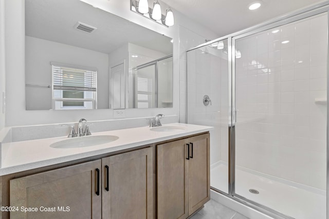 bathroom featuring vanity, tile patterned flooring, and walk in shower