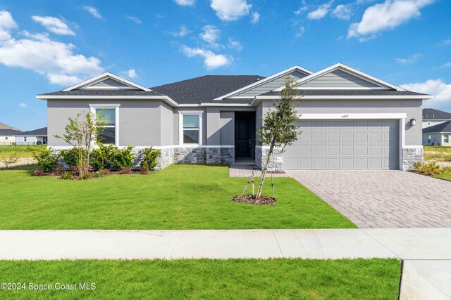 view of front of home with a front lawn and a garage