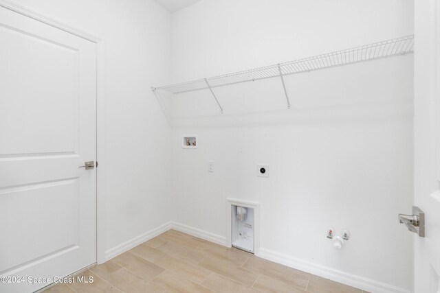clothes washing area featuring washer hookup, electric dryer hookup, hookup for a gas dryer, and hardwood / wood-style floors