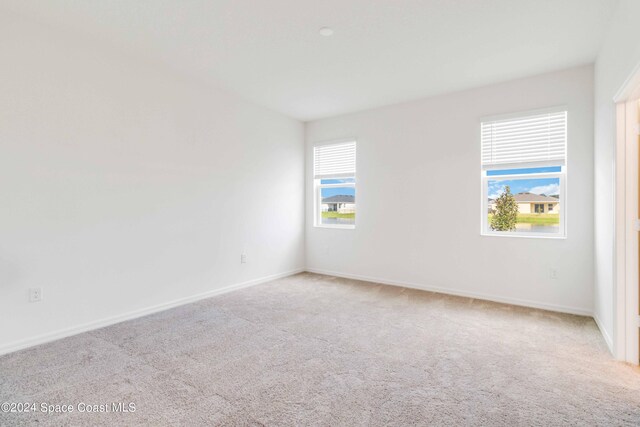 unfurnished room featuring light carpet