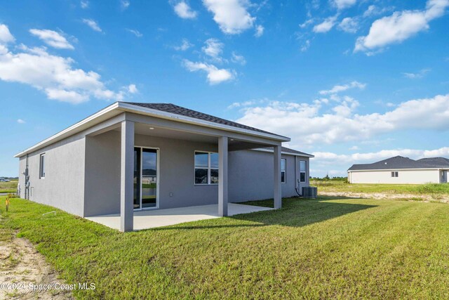 back of house with a patio area, central air condition unit, and a lawn