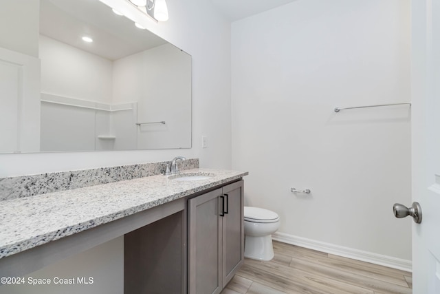 bathroom with hardwood / wood-style floors, vanity, and toilet