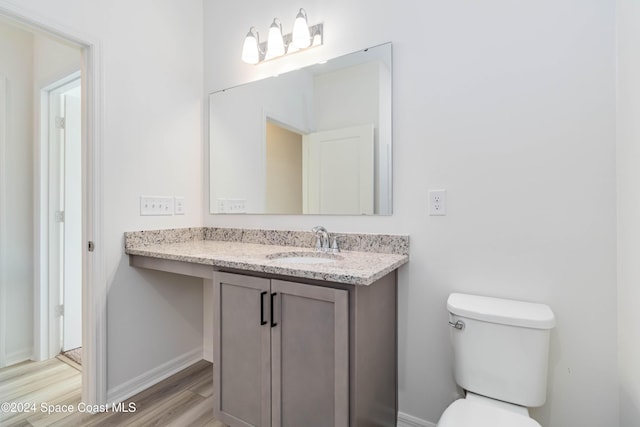 bathroom featuring wood-type flooring, vanity, and toilet