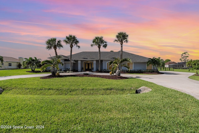 ranch-style home with a yard