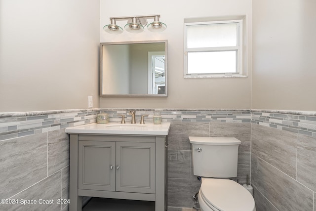 bathroom with tile walls, toilet, decorative backsplash, and vanity