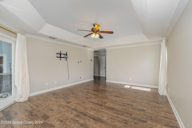 spare room featuring a tray ceiling, ceiling fan, ornamental molding, and hardwood / wood-style flooring