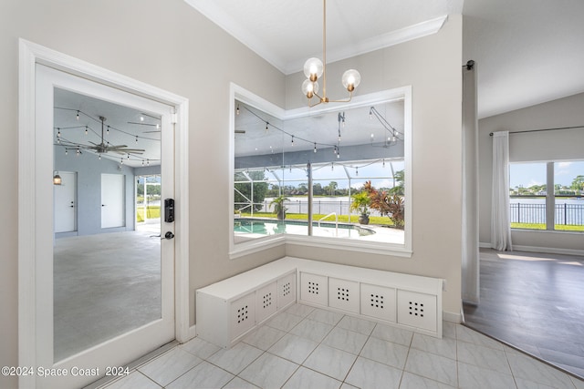 unfurnished dining area with ceiling fan with notable chandelier, a healthy amount of sunlight, and light tile patterned floors