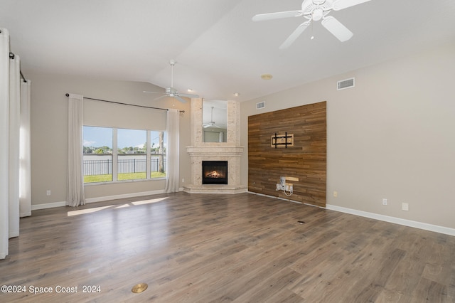 unfurnished living room featuring ceiling fan, lofted ceiling, a large fireplace, and hardwood / wood-style floors