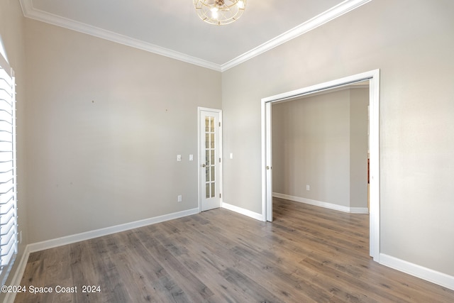 unfurnished bedroom featuring a closet, crown molding, and wood-type flooring