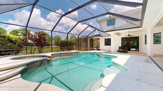 view of pool with glass enclosure, ceiling fan, an in ground hot tub, and a patio