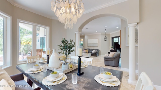 dining room with crown molding, a chandelier, light tile patterned floors, and decorative columns