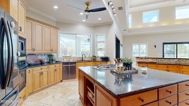 kitchen featuring ceiling fan, stainless steel appliances, decorative backsplash, and a kitchen island