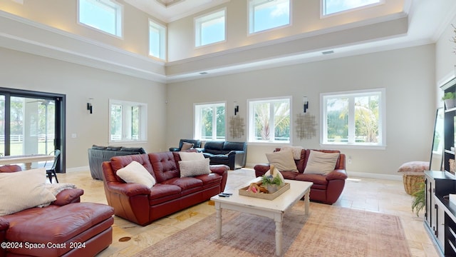 living room with crown molding, light tile patterned flooring, and a towering ceiling