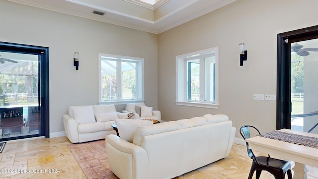 tiled living room with ceiling fan and ornamental molding