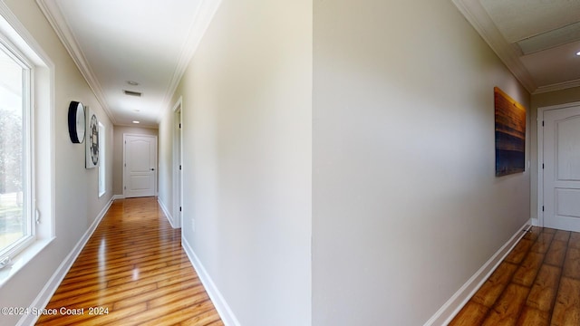 corridor with hardwood / wood-style flooring and ornamental molding