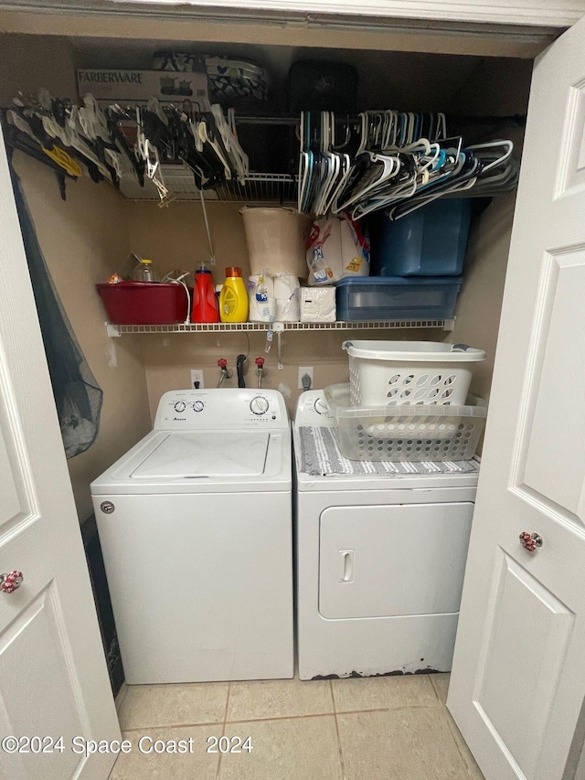 washroom with light tile patterned floors and washing machine and clothes dryer