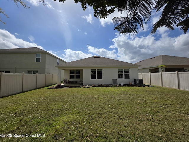 back of house featuring cooling unit, a fenced backyard, a lawn, and stucco siding