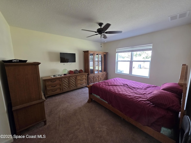 bedroom featuring a textured ceiling, ceiling fan, carpet, and visible vents