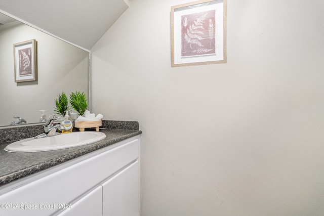 bathroom with lofted ceiling and vanity