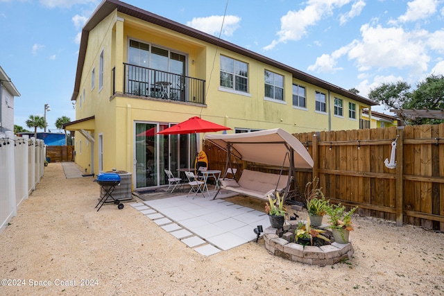 back of property with a balcony and a patio area