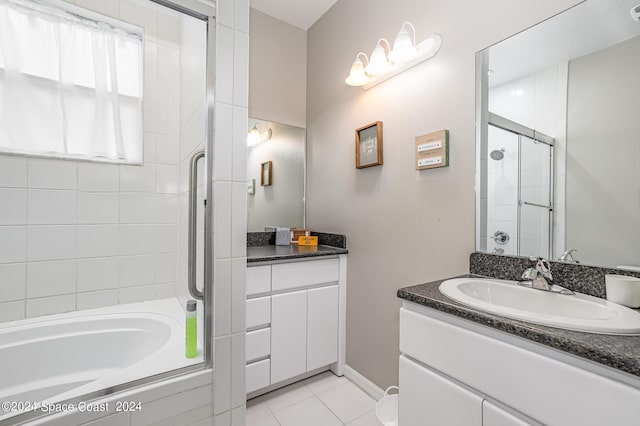 bathroom with tile patterned floors, a relaxing tiled tub, and vanity