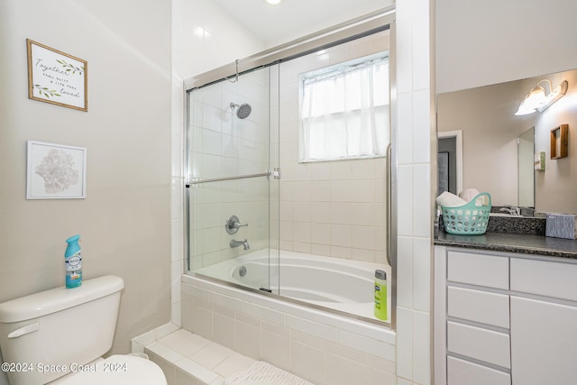 full bathroom featuring toilet, vanity, and enclosed tub / shower combo