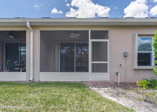 560 Remington Green Dr SE Unit 103, Palm Bay, FL 32909 - rear view of house featuring stucco siding, a sunroom, a lawn, and ceiling fan