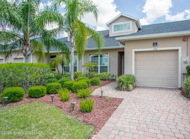 560 Remington Green Dr SE Unit 103, Palm Bay, FL 32909 - view of front facade with a shingled roof, a garage, driveway, and stucco siding
