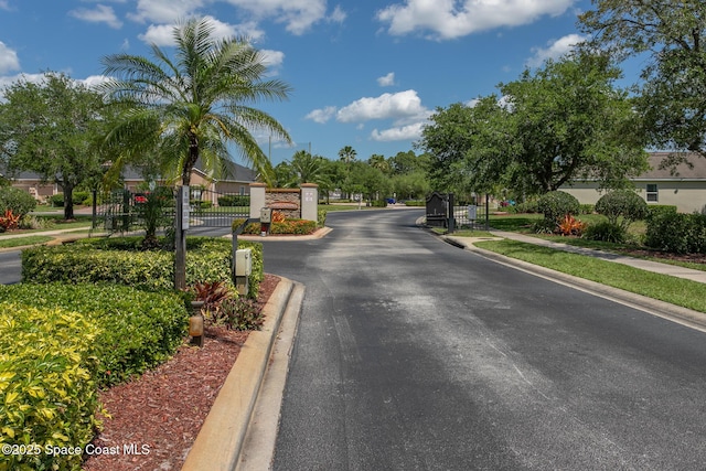 560 Remington Green Dr SE Unit 103, Palm Bay, FL 32909 - view of street with a gated entry, sidewalks, a gate, and curbs