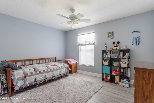 bedroom with baseboards, a ceiling fan, and wood finished floors