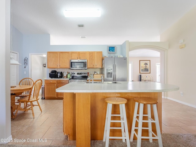kitchen with visible vents, a sink, stainless steel appliances, and light tile patterned floors
