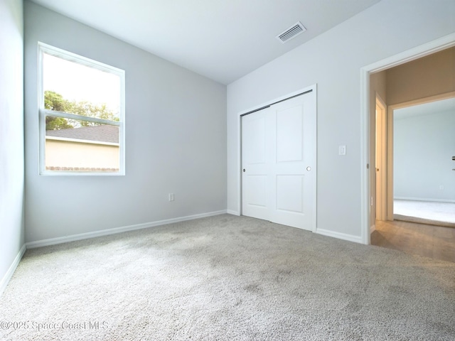 unfurnished bedroom featuring carpet flooring and a closet