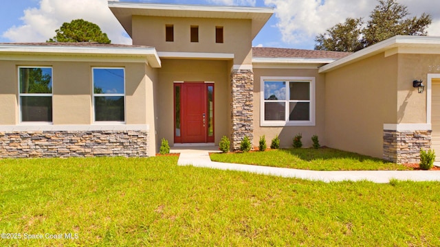 view of exterior entry with a yard