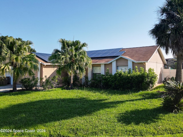 view of front of house with a front lawn and solar panels