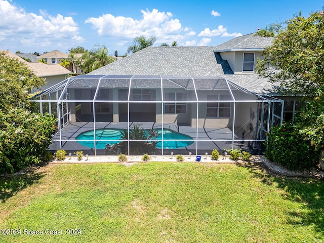 rear view of house with a lawn, a lanai, and a patio area