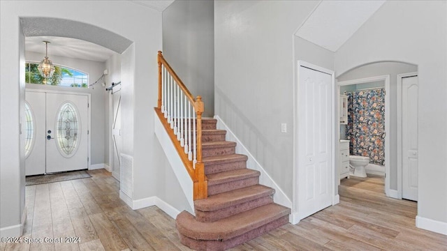 entrance foyer with a high ceiling, light hardwood / wood-style floors, and french doors