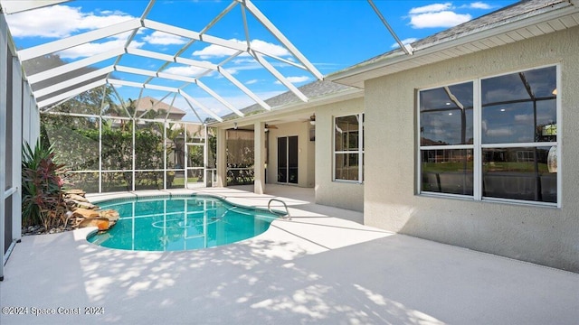 view of pool with a lanai, ceiling fan, and a patio area