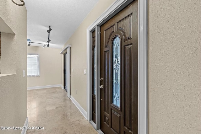 interior space with a textured ceiling and light tile patterned floors