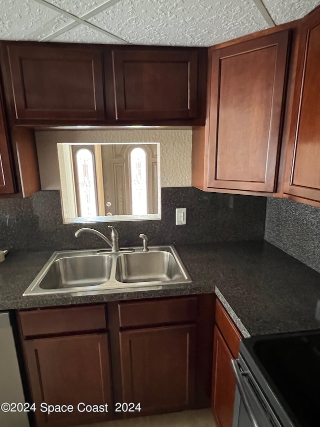 kitchen featuring a paneled ceiling, decorative backsplash, stainless steel appliances, and sink