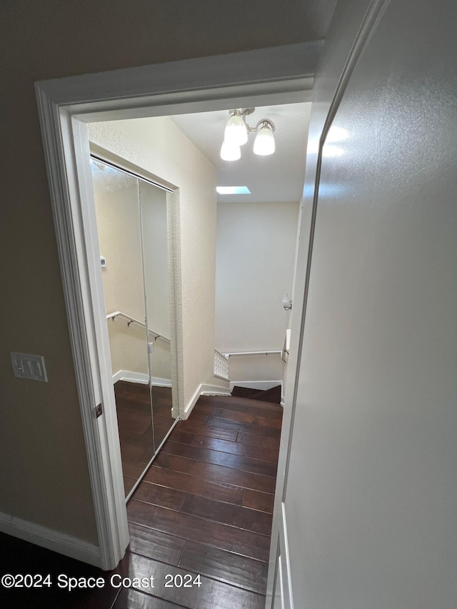 hall with a chandelier and dark hardwood / wood-style flooring