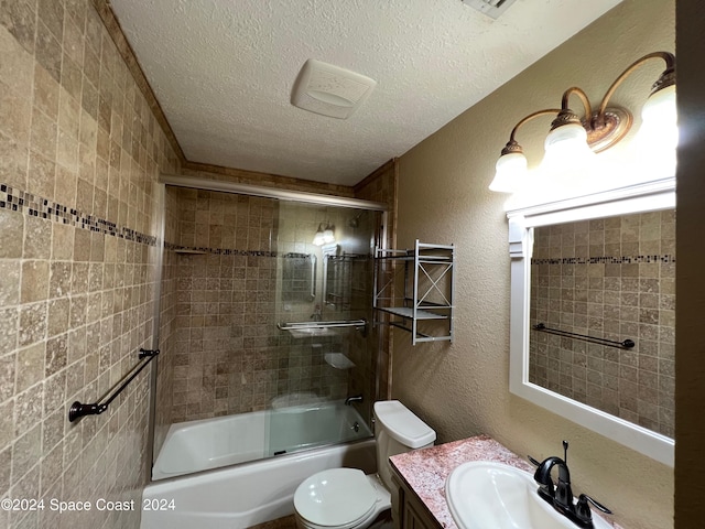 full bathroom featuring a textured ceiling, vanity, toilet, and enclosed tub / shower combo