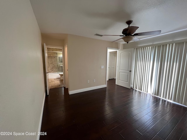 spare room featuring dark hardwood / wood-style flooring, ceiling fan, and a textured ceiling