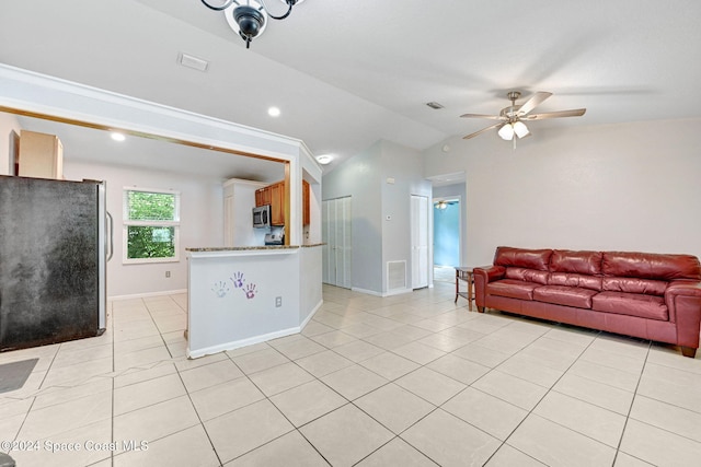 living room featuring vaulted ceiling, light tile patterned floors, and ceiling fan