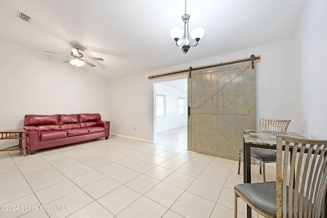 tiled living room with a barn door and ceiling fan with notable chandelier